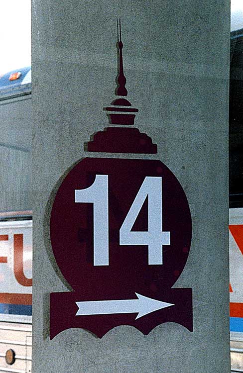 a sign of a silhouette of the top of a building with the number '14' and an arrow on top of it